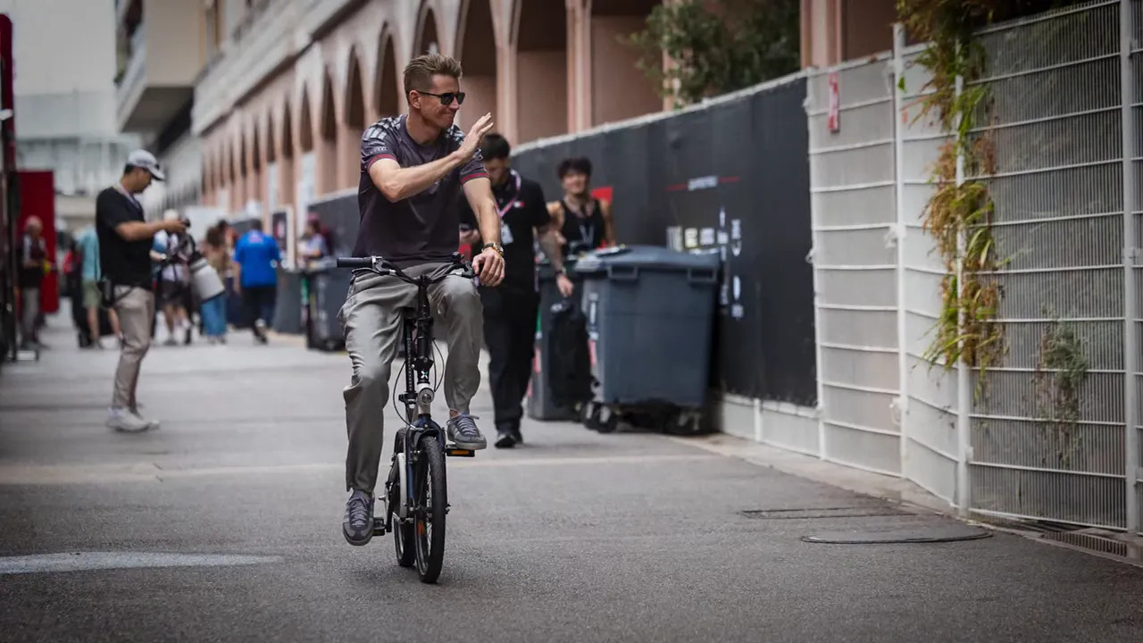 Driver riding a bicycle down a narrow Monaco lane
