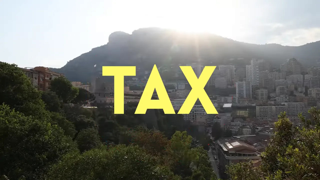 Red crossed out tax symbol over a Monaco hillside view