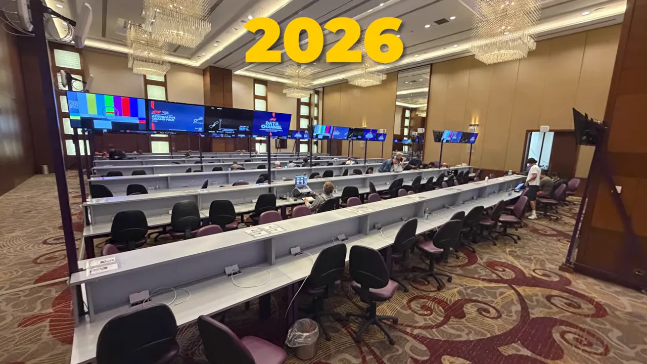 Media center with long rows of desks, chairs and overhead screens