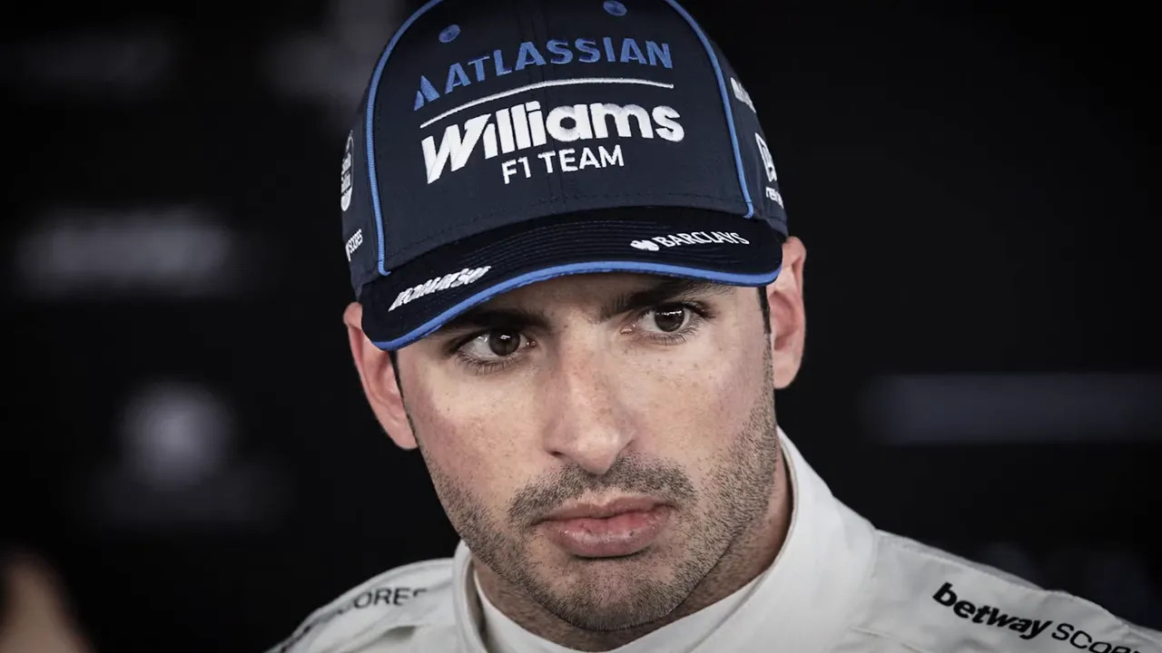 Carlos Sainz standing beside drivers championship standings showing him in fifteenth place