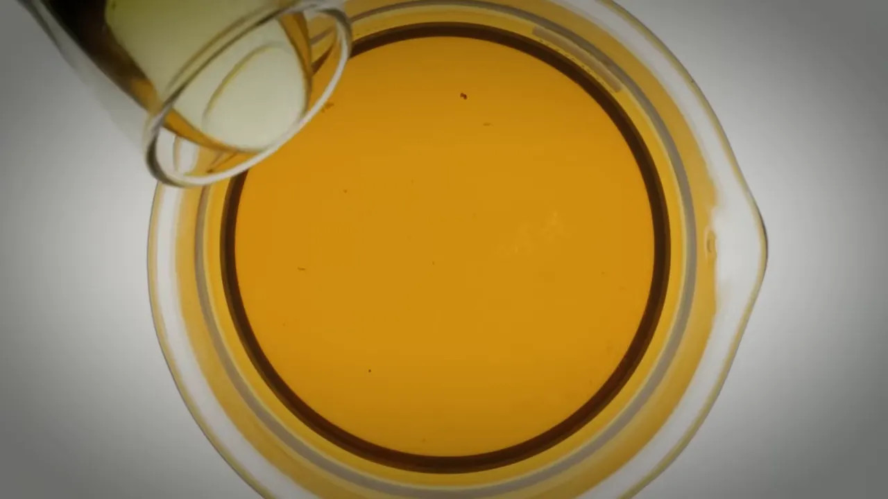 Close-up view of orange liquid fuel inside a sealed container in an FIA fuel supply process