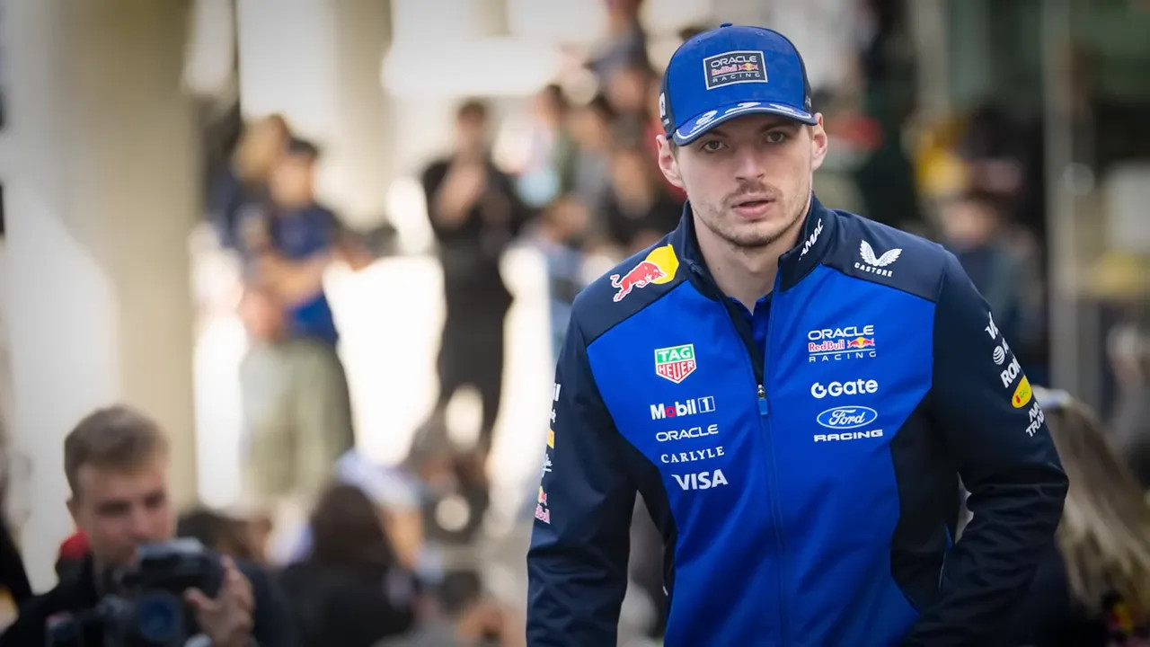 Max Verstappen in Red Bull team apparel with photographers blurred in the background