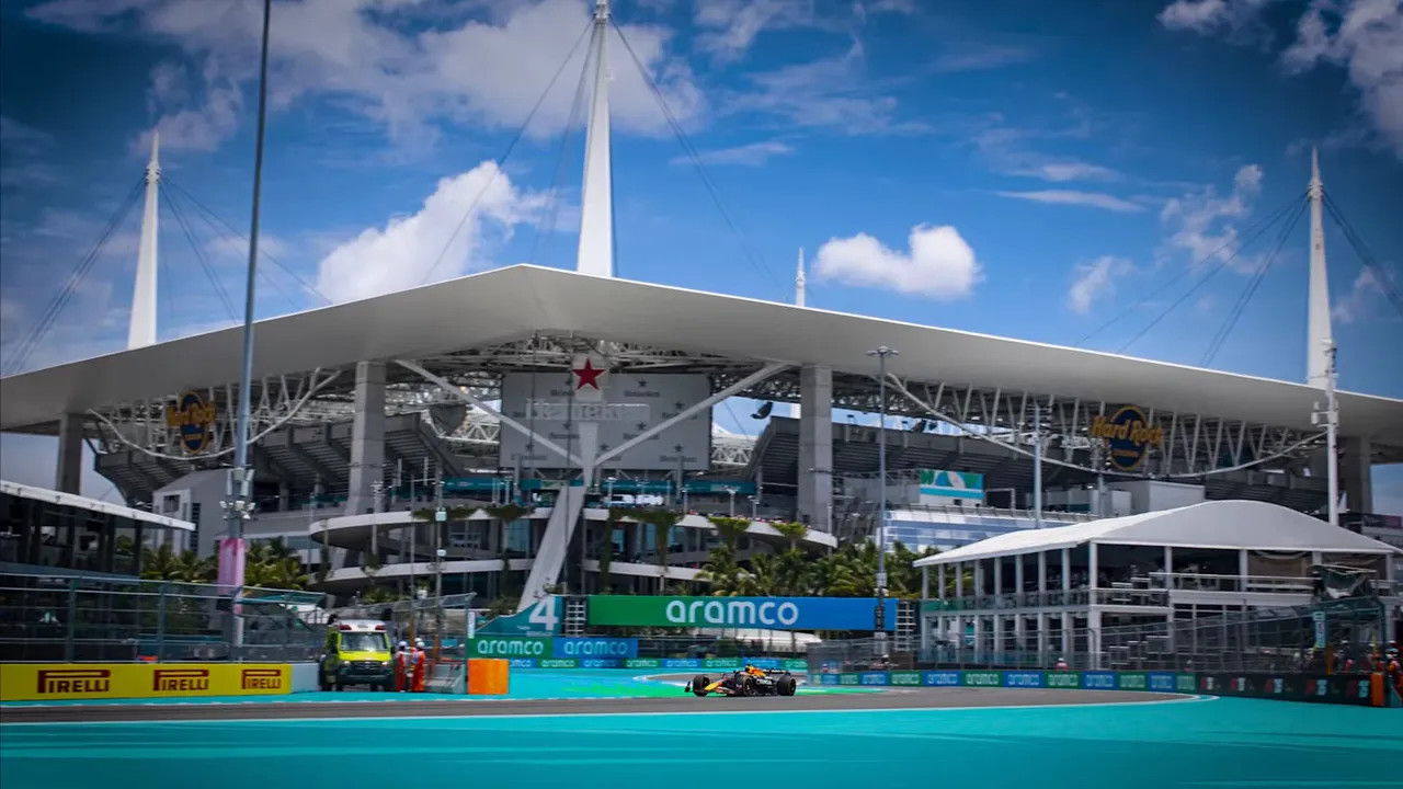 Miami Grand Prix stadium with an F1 car on track in front of Hard Rock Stadium