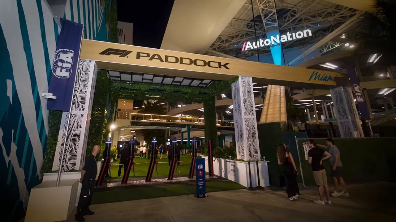 Miami GP paddock entrance signage and pathway in a bustling event area
