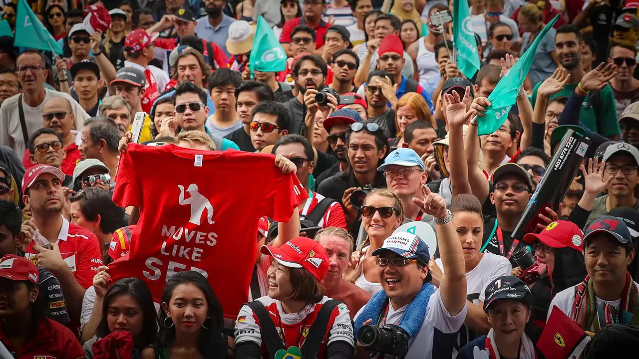 Large crowd of Formula 1 fans waving and holding flags