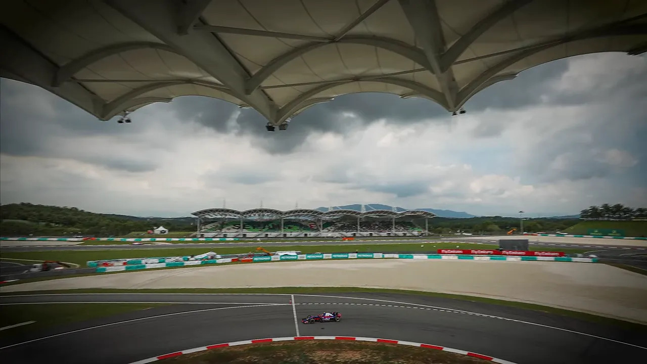 Two Formula 1 cars side by side through a Sepang corner