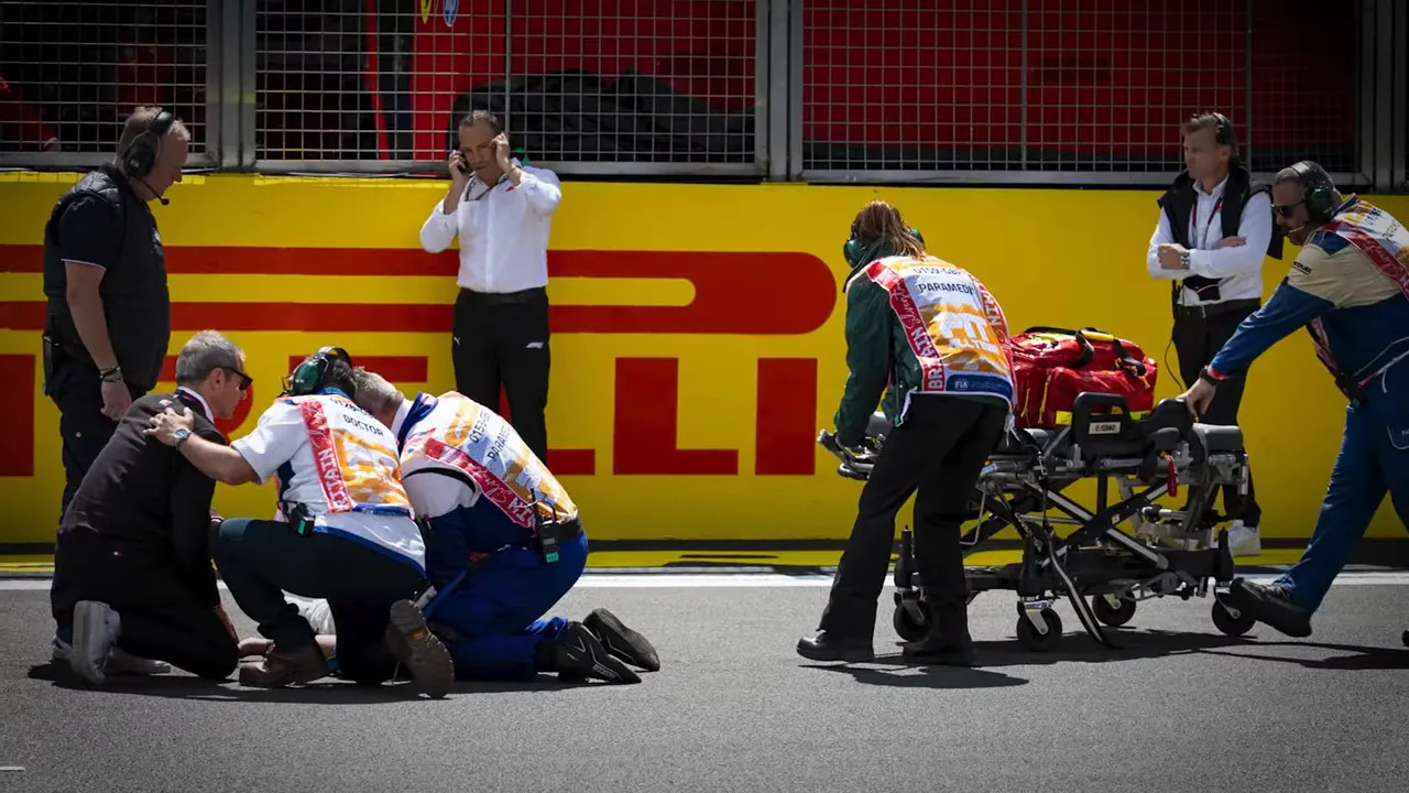 Medical staff kneeling beside a person on track with a stretcher nearby