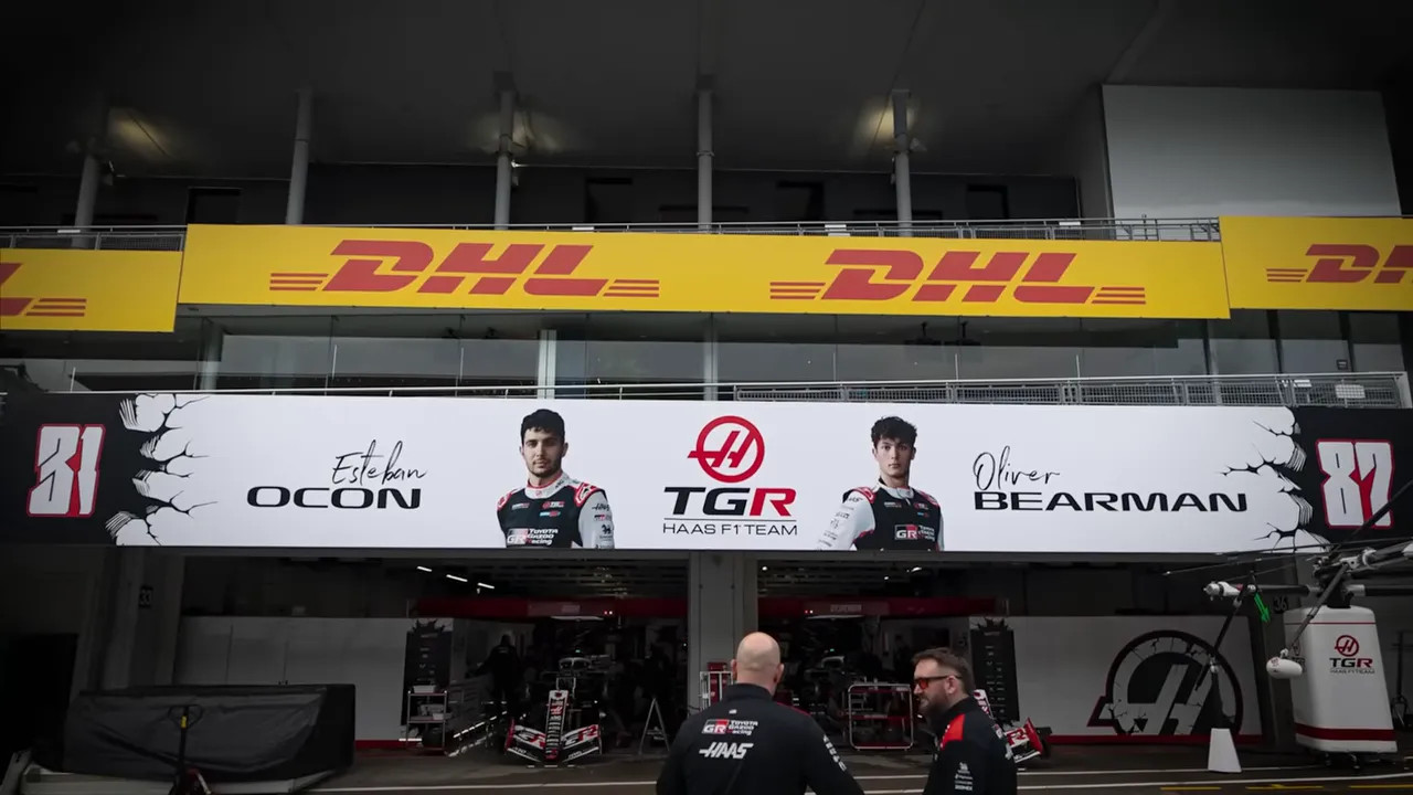 Haas garage area with drivers and team branding in the paddock