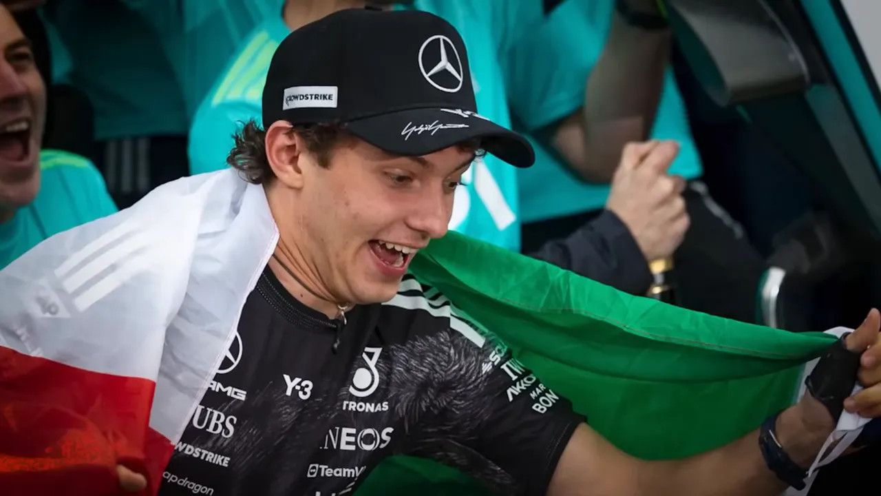 Kimi Antonelli celebrating on the podium with the Mercedes flag at the 2026 Japanese Grand Prix