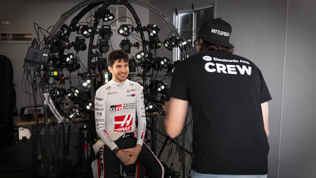 Driver seated and smiling inside a multi-camera face-capture rig while a crew member adjusts equipment